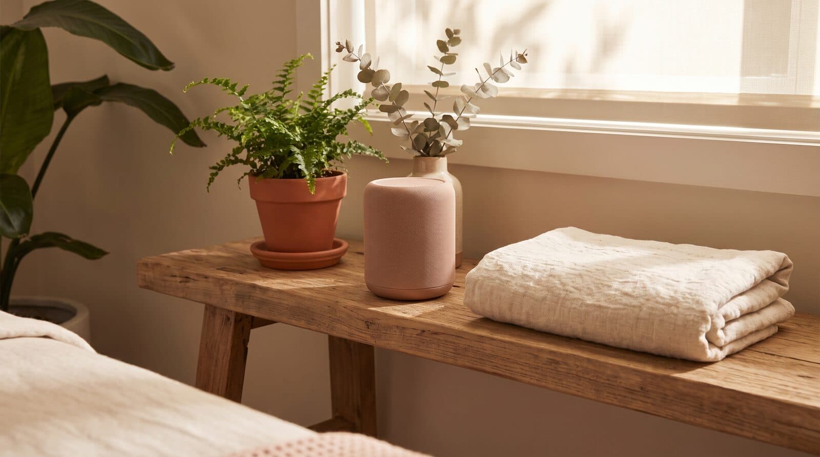 Fern & Soul massage studio in Innaloo, a small speaker beside a folded cream towel on a treatment room shelf in soft light.