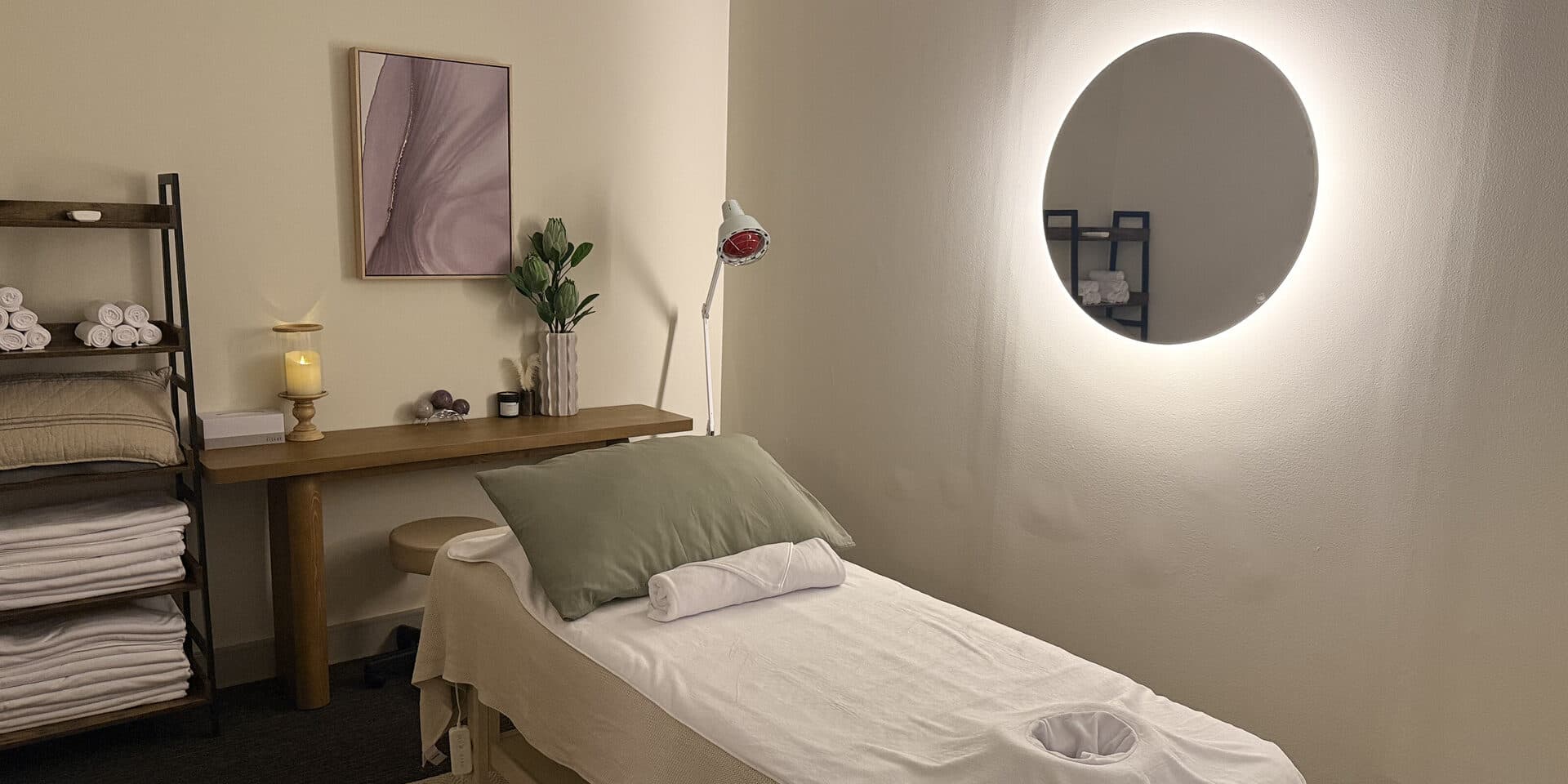 Remedial massage treatment room at Fern & Soul Innaloo with an infrared heat lamp, candlelight and a made-up massage table